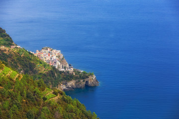 Seacoast with deep blue sea and village with colorful houses on the slope in Cinque Terre, the Liguria region