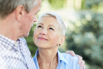 portrait of loving senior couple embracing and looking at each other focus on elegant woman smiling 