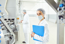 A Woman In A White Uniform With A Folder In Her Hand Controls The Production Process.