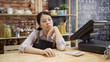 © PRPicturesProduction - bored waitress girl in apron sitting in cafe bar counter with hand in chin looking out store. depressed coffee shop owner with no customer visiting. unhappy lady worried about small startup business