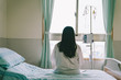 © PR Image Factory - female patient with dropper looks out the window
