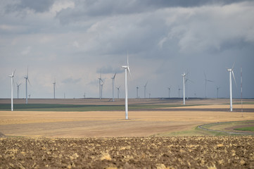 Wind turbines in a wind farm with a dramatic stormy sky in the background