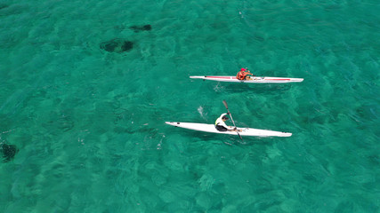 Wall Mural - Aerial drone photo of fit men practising sport canoe in tropical open ocean bay with turquoise clear sea