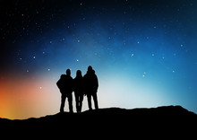 Travel, Hike And Success Concept - Group Of Travelers Or Friends Standing On Edge Of Hill Over Starry Night Sky Or Space Background
