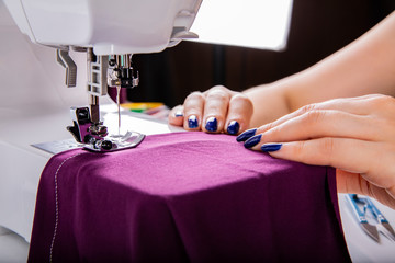 Sewing on the machine. The woman is sewn.