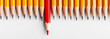 Red pencil protruding out of row with classic ones