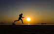 © AFZALKHAN - Silhouette of athletic running on the sun rise beach.