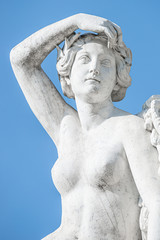 Old statue of sensual renaissance era woman at blue smooth background, Potsdam, Germany, details, closeup