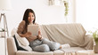 © Prostock-studio - Happy Girl Surfing Internet On Tablet, Resting at Home