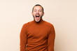 © luismolinero - Colombian man with turtleneck sweater shouting to the front with mouth wide open