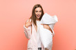 © luismolinero - Young woman in dressing gown over pink wall with surprise facial expression