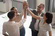 © fizkes - Happy motivated diverse business team people giving high five together