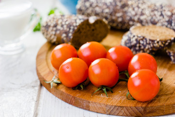 Bunch of cherry tomatoes over wooden board.