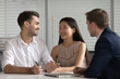 © fizkes - Smiling mixed ethnicity family couple talk consider mortgage loan offer