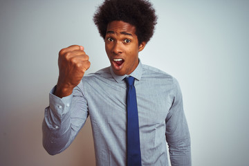 Poster - American business man with afro hair wearing shirt and tie over isolated white background angry and mad raising fist frustrated and furious while shouting with anger. Rage and aggressive concept.