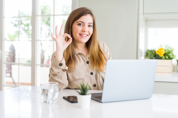 Sticker - Beautiful young woman using computer laptop doing ok sign with fingers, excellent symbol