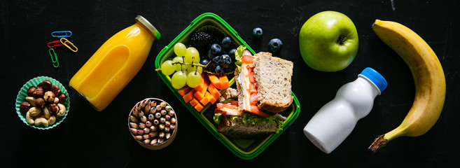 Wall Mural - Back to school concept - lunch box with juice, apple and banana, copy space