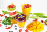 Fototapeta Kuchnia - Wielowarstwowe kolorowe smoothie z mango, borówką amerykańską, kiwi, selerem naciowym, porzeczkami, malinami i jarmużem