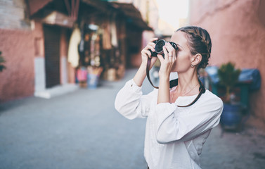 Wall Mural - Tourism and technology. Happy young woman taking photo of  Marrakesh old town. Traveling by Morocco.