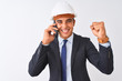 © Krakenimages.com - Young architect man wearing helmet talking on smartphone over isolated white background screaming proud and celebrating victory and success very excited, cheering emotion