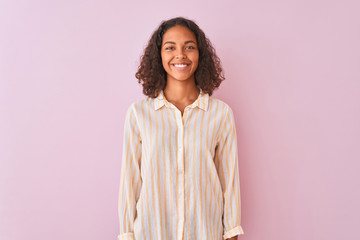 Young brazilian woman wearing striped shirt standing over isolated pink background with a happy and cool smile on face. Lucky person.