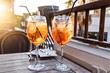 Two wine glass of cold cocktail Aperol spritz on background of restaurant. Traditional Italian Aperitif Cocktail concept