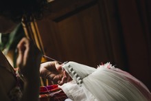 Female Seamstress Patching A Wedding Dress With Thread And Needles In A Handmade Way At Home.