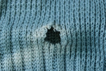 gray background of woolen fabric with a hole