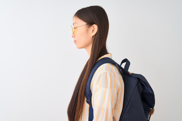 Young chinese student woman wearing glasses and backpack over isolated white background looking to side, relax profile pose with natural face with confident smile.