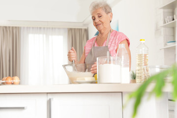 Poster - Portrait of beautiful grandmother cooking in kitchen