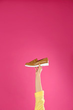 Young Woman Holding Comfortable Shoe On Pink Background, Closeup