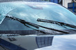 Washing car windscreen with wipers and liquid, closeup