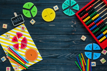 Creative fractions on wooden background. Interesting funny math for kids. Education, back to school concept. Geometry and mathematics materials. Flat lay, top view	