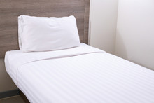 White Single Bed And Pillow In The Bed Room Close Up.