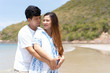 © DG PhotoStock - Photograph of happy Asian family at the beach, wife in pregnancy.