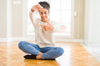 © Krakenimages.com - Beautiful young african american woman with afro hair sitting on the floor smiling making frame with hands and fingers with happy face. Creativity and photography concept.