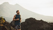 Young athlete man trail running in mountains in the morning. Healthy lifestyle concept. Panoramic photo with empty copy space.