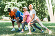 © LIGHTFIELD STUDIOS - selective focus of happy retired and multicultural people doing stretching exercise on grass