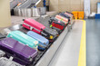 Bright colorful suitcases on luggage conveyor belt in airport
