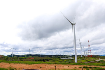 Wind generators turbines on sunset summer with mountain and blue sky landscape.