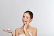 © verona_studio - Beauty Woman Concept. Skin care. Young model with Soft skin holding cosmetic cream. Portrait of female applying moisturizing cream and touch own face. Skin Protection