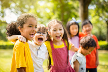 multi-ethnic group of school children laughing and embracing