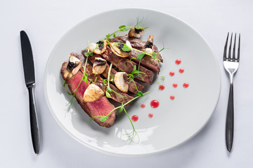 Wall Mural - chopped beef steak with champignons, young peas and red sauce