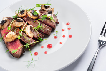 Wall Mural - chopped beef steak with champignons, young peas and red sauce