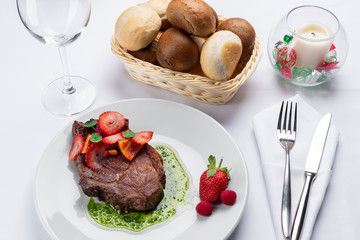 Wall Mural - beef stake with strawberry on white dish and basil saus