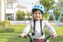 Smiling Boy In Safety Helmet Riding His Bike.asian Child On A Bicycle At Asphalt Road In Summer. Bike In The Park
