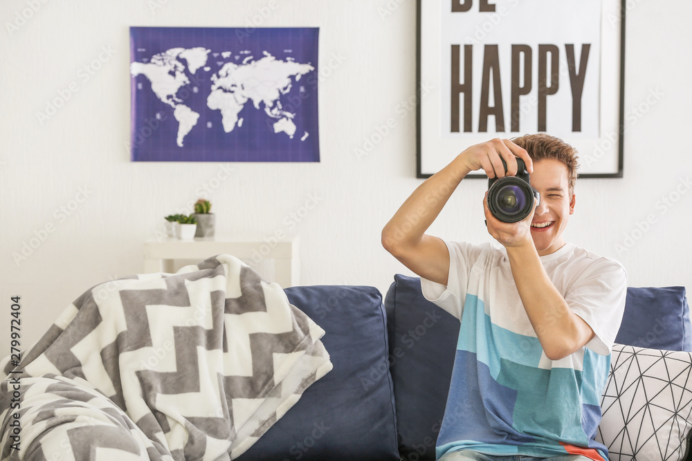 Teenage boy with photo camera at home
