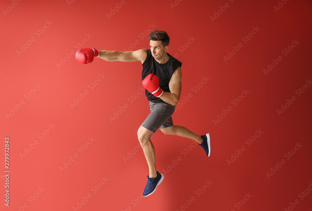 Sporty male boxer on color background