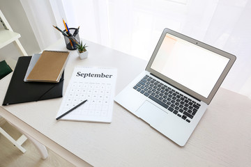 Flip calendar with laptop on table in room