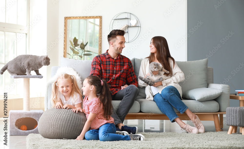 Happy family with cute cats resting at home